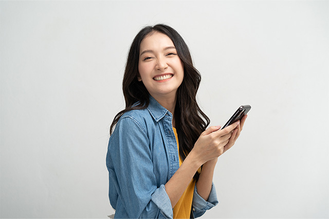 スマホを持って笑顔の女性